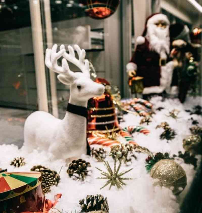 A Christmas themed storefront with reindeer and Santa props