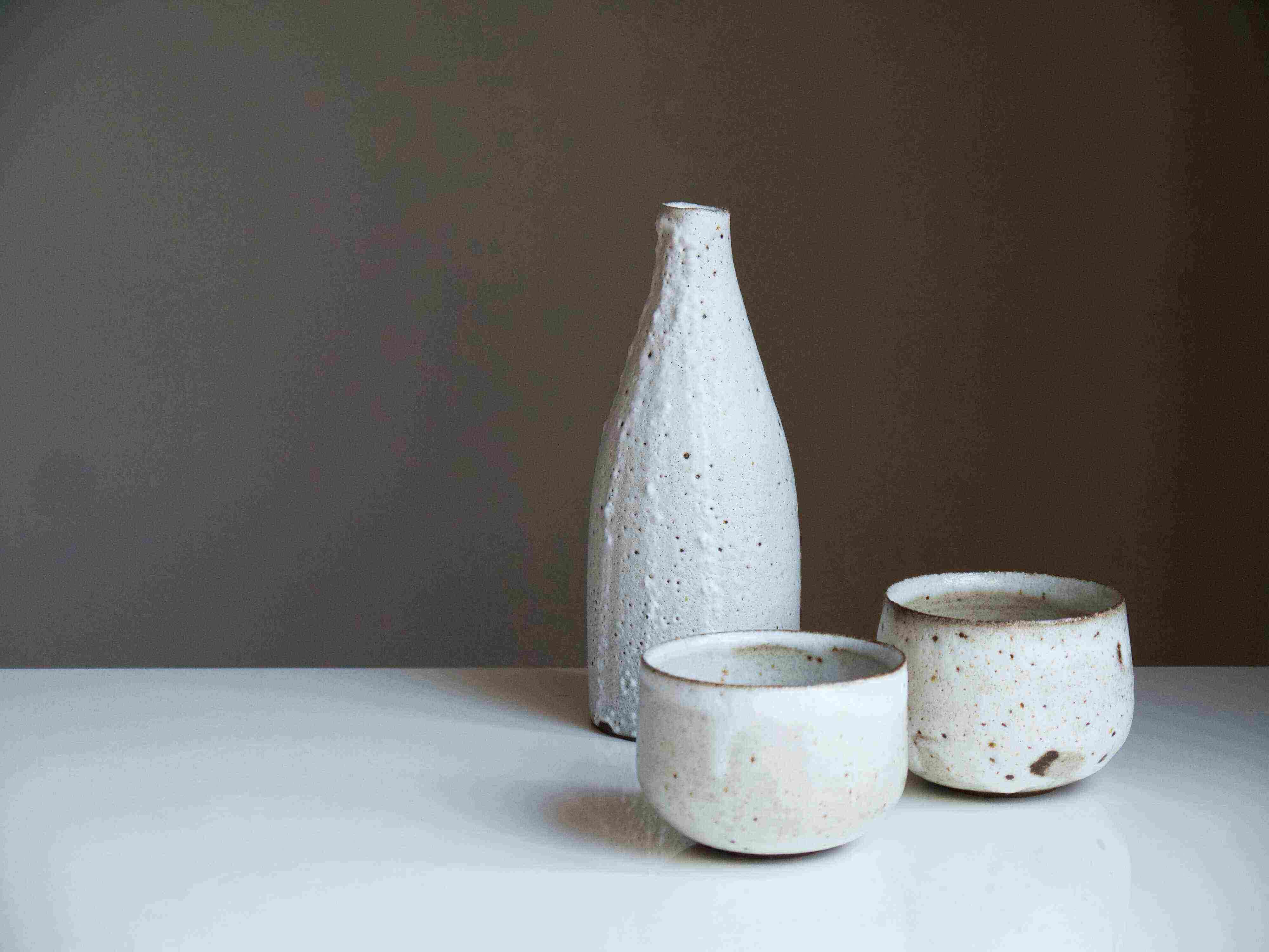 Three white stoneware offerings placed on a table