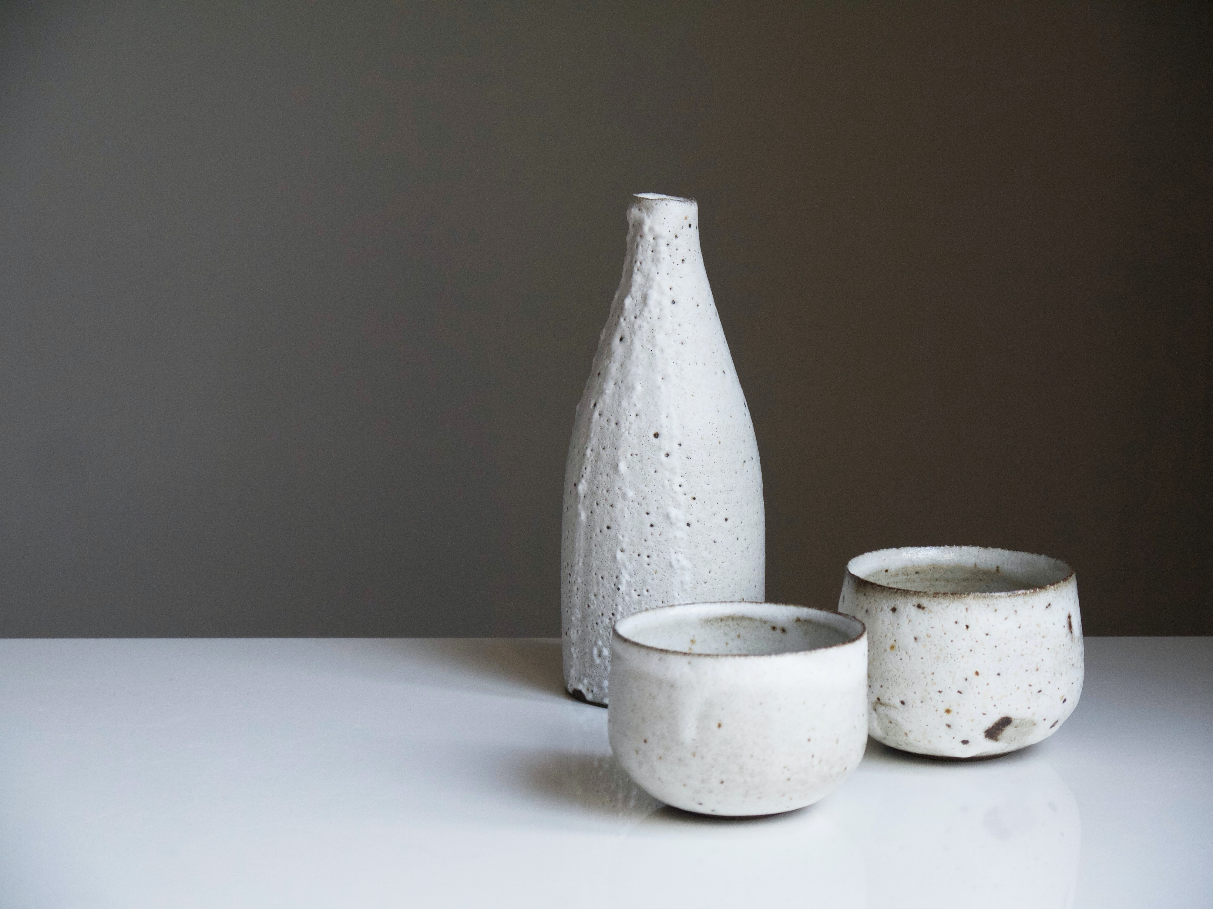 Three white stoneware offerings placed on a table