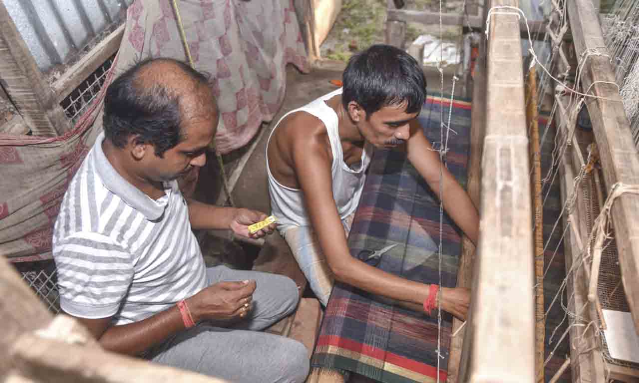 Two men operating a hand loom