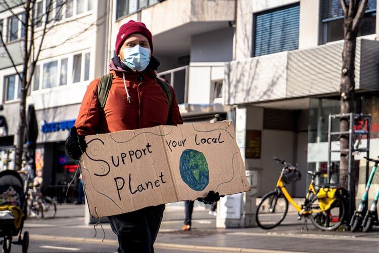 A man holding Support Planet placard