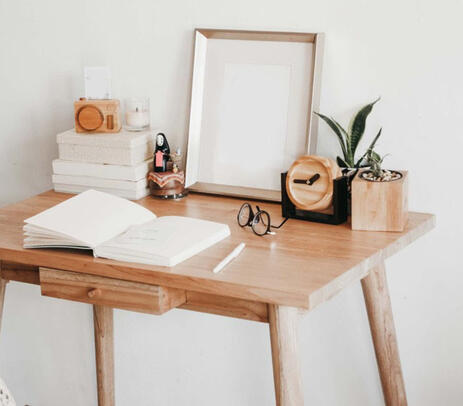 Hand cut wooden scandinavian work desk with plants, books and frame on top