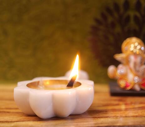 Diya with Lord Ganesh idol in the background