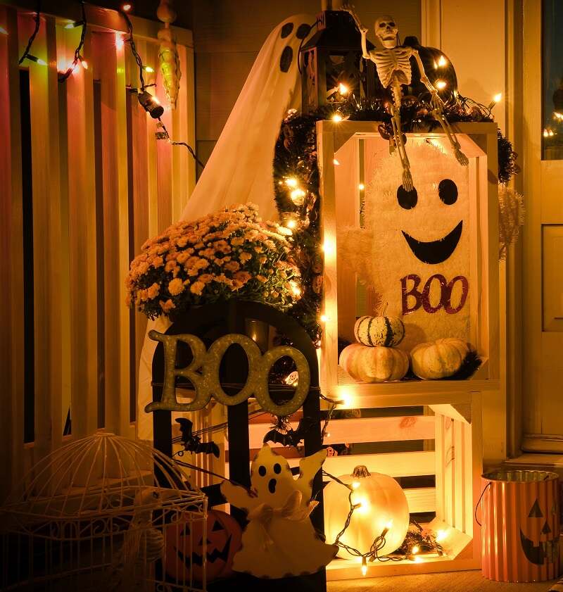 Halloween patio area decoration with skeletons, ghosts, and pumpkins