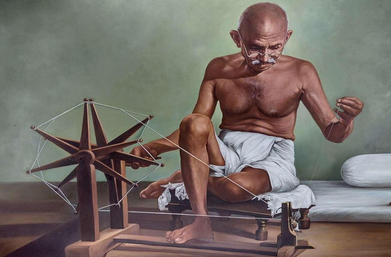 Mahatma Gandhi operating a charkha