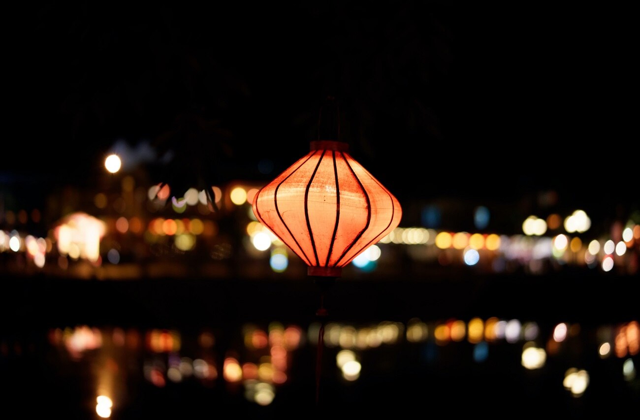 A lantern glowing against the background of the city at night