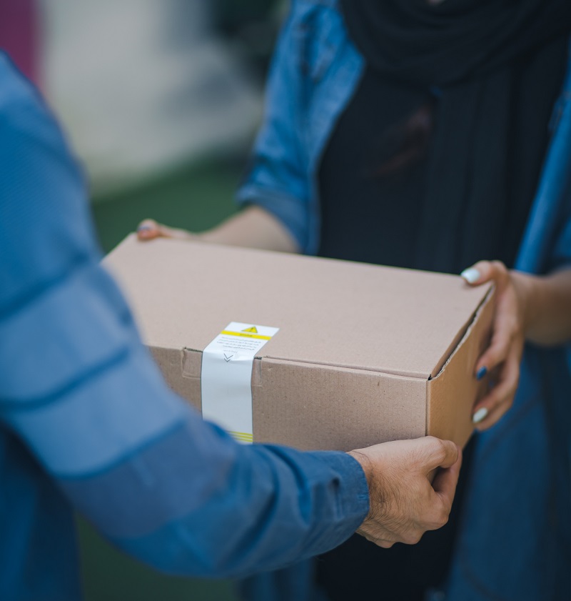 A parcel being delivered into the hands of the receiver
