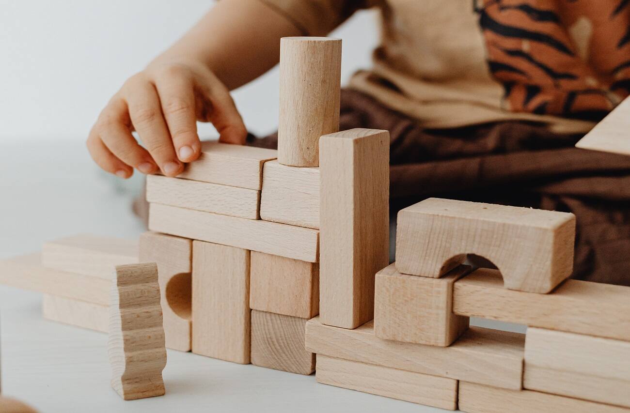 hands of a little kid playing with building blocks