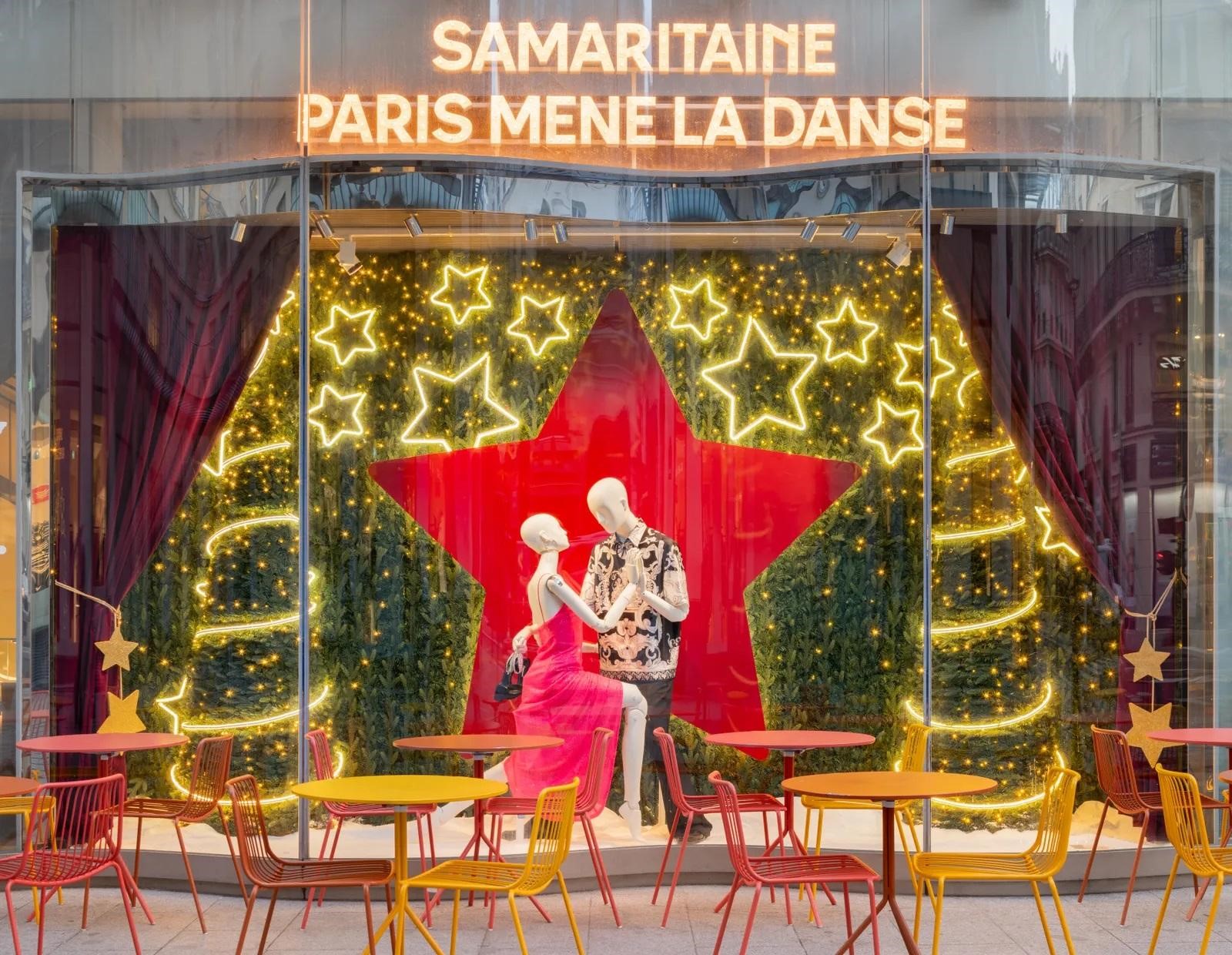 Christmas-themed storefront with a couple mannequin in a dancing stance surrounded by Christmas trees and star lights