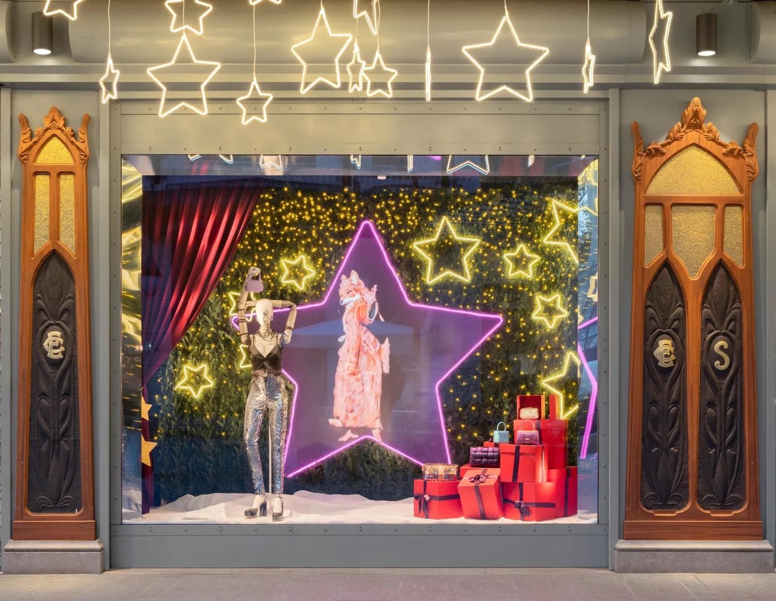 Very Peri color theme storefront with a Chrsitmas-motif set-up consisting mannequin, bunch of gifts, star light and a she-fox figure in the center of a star