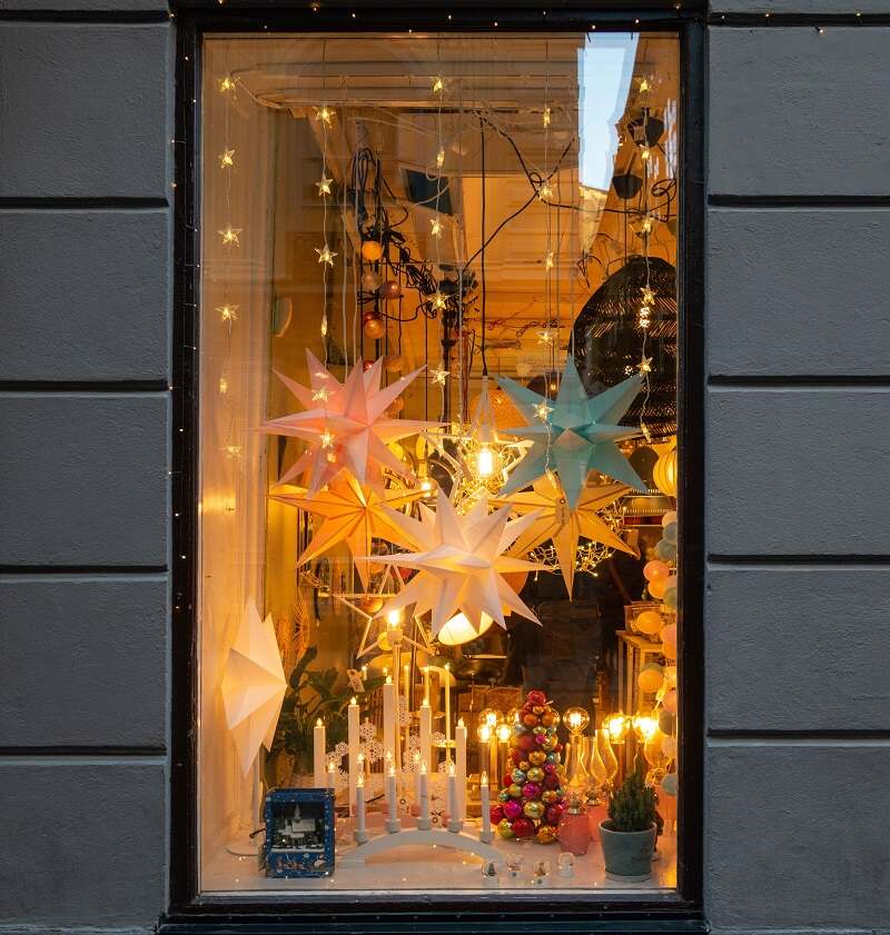 A christmas themed-storefront with star hangings, candles and dangling lights