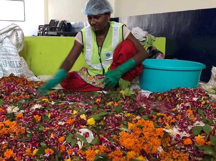 A woman artisan sorting through discarded flower waste