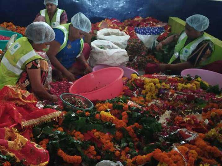 A group of women artisans sorting through discarded flower waste