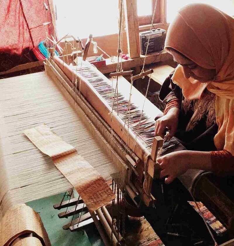 Artisans weaving pashmina wool on a wooden loom
