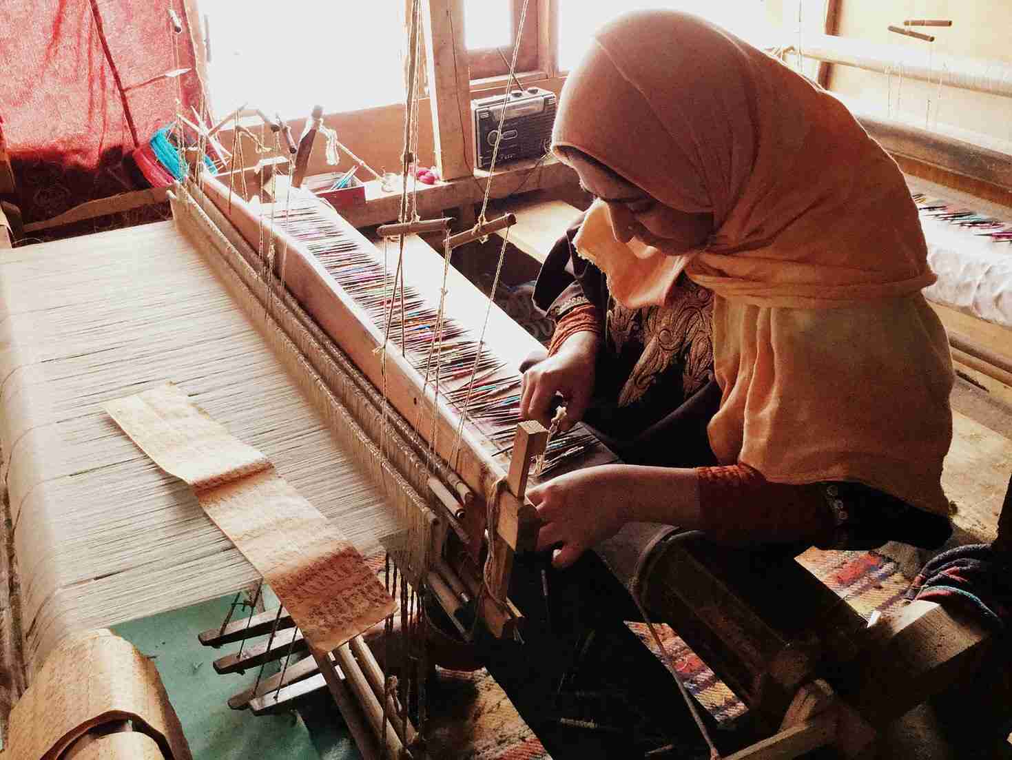 Artisans weaving pashmina wool on a wooden loom