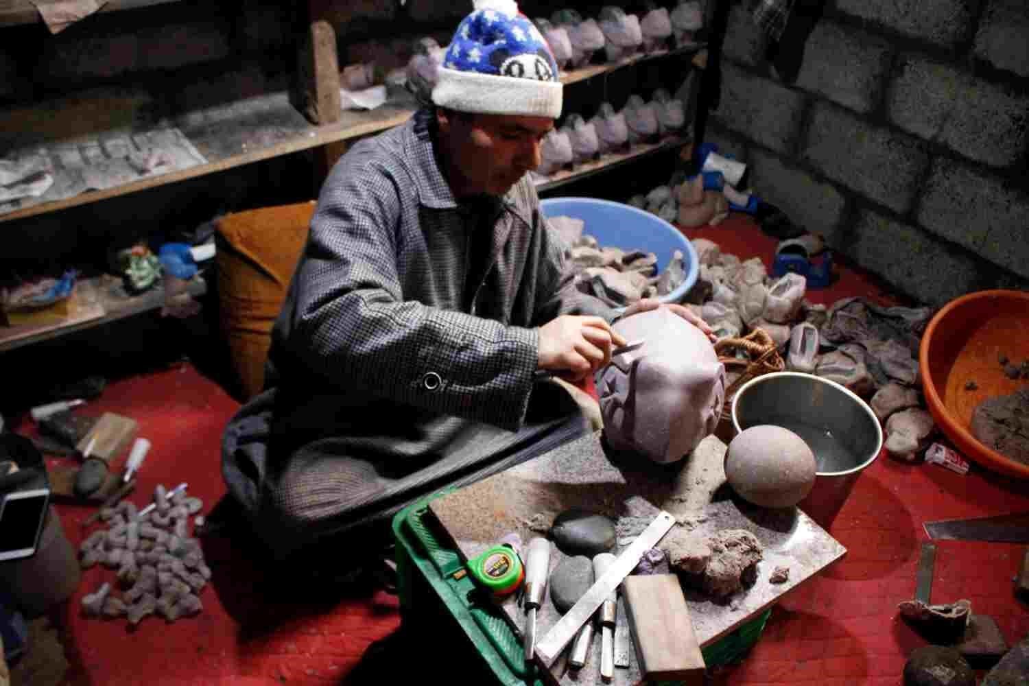 An artisan working on a papier mache artefact