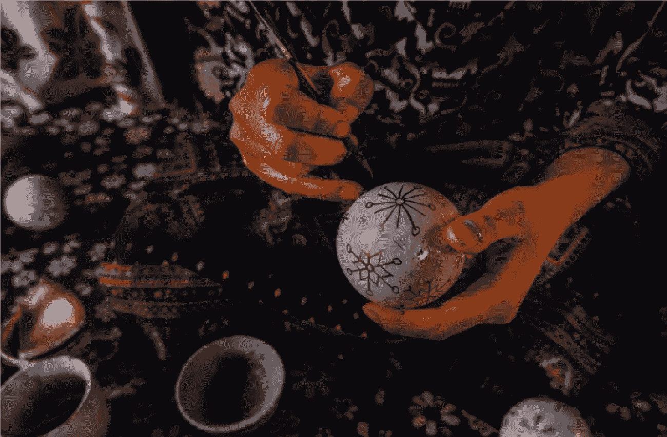A pair of hands embellishing a decorative offering