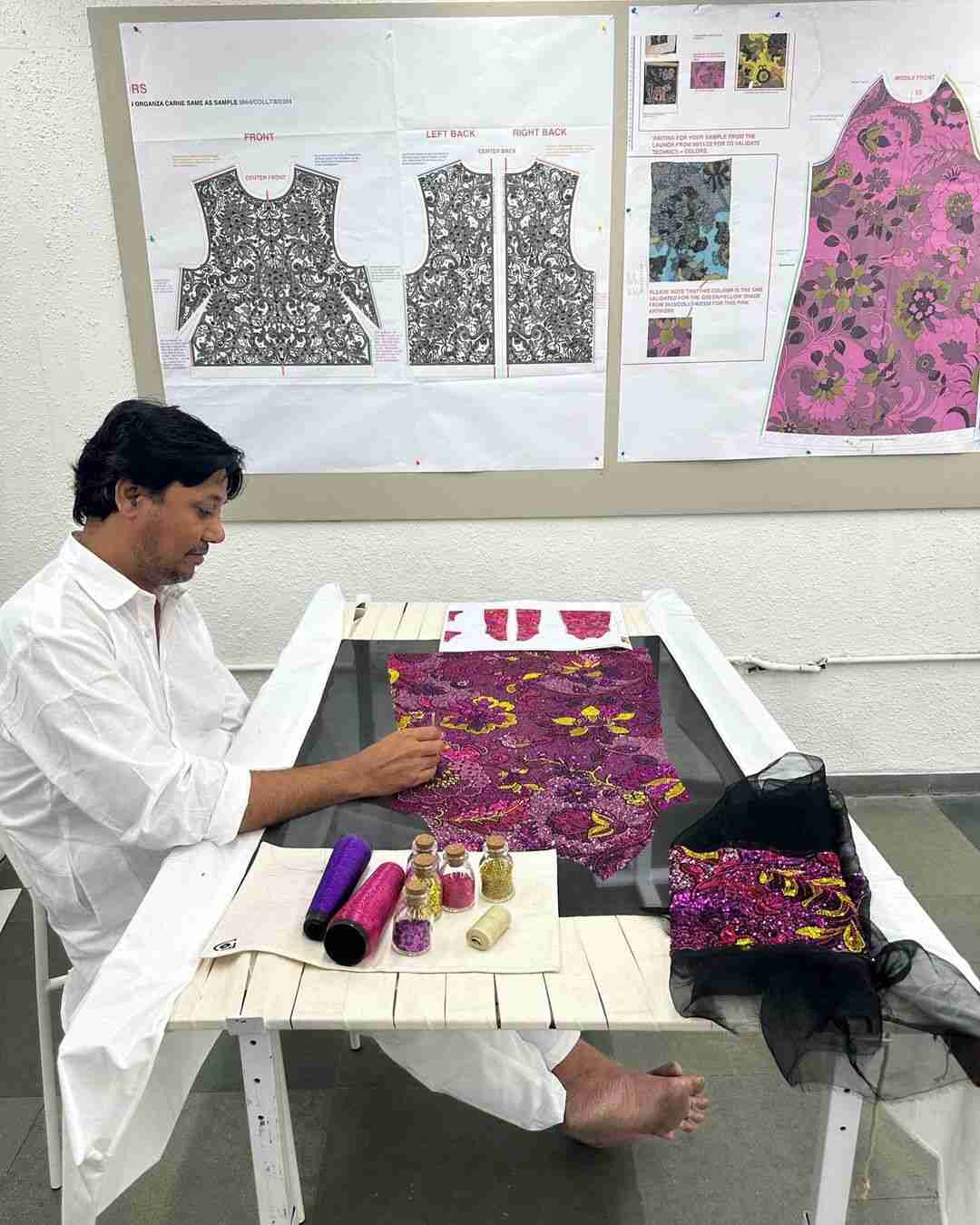 An artisan embellishing an apparel with embroidery
