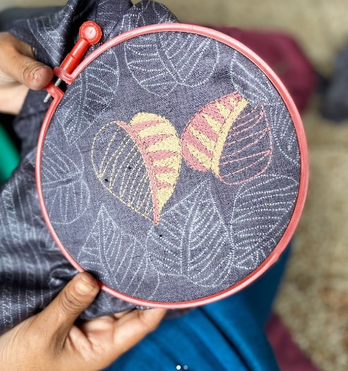 An artisan showing phulkari embroidery stitches